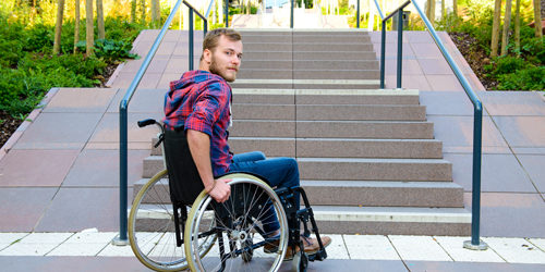 Man in wheelchair in front of stairs