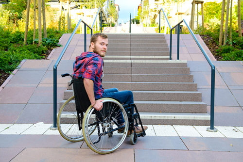 Man in wheelchair in front of stairs